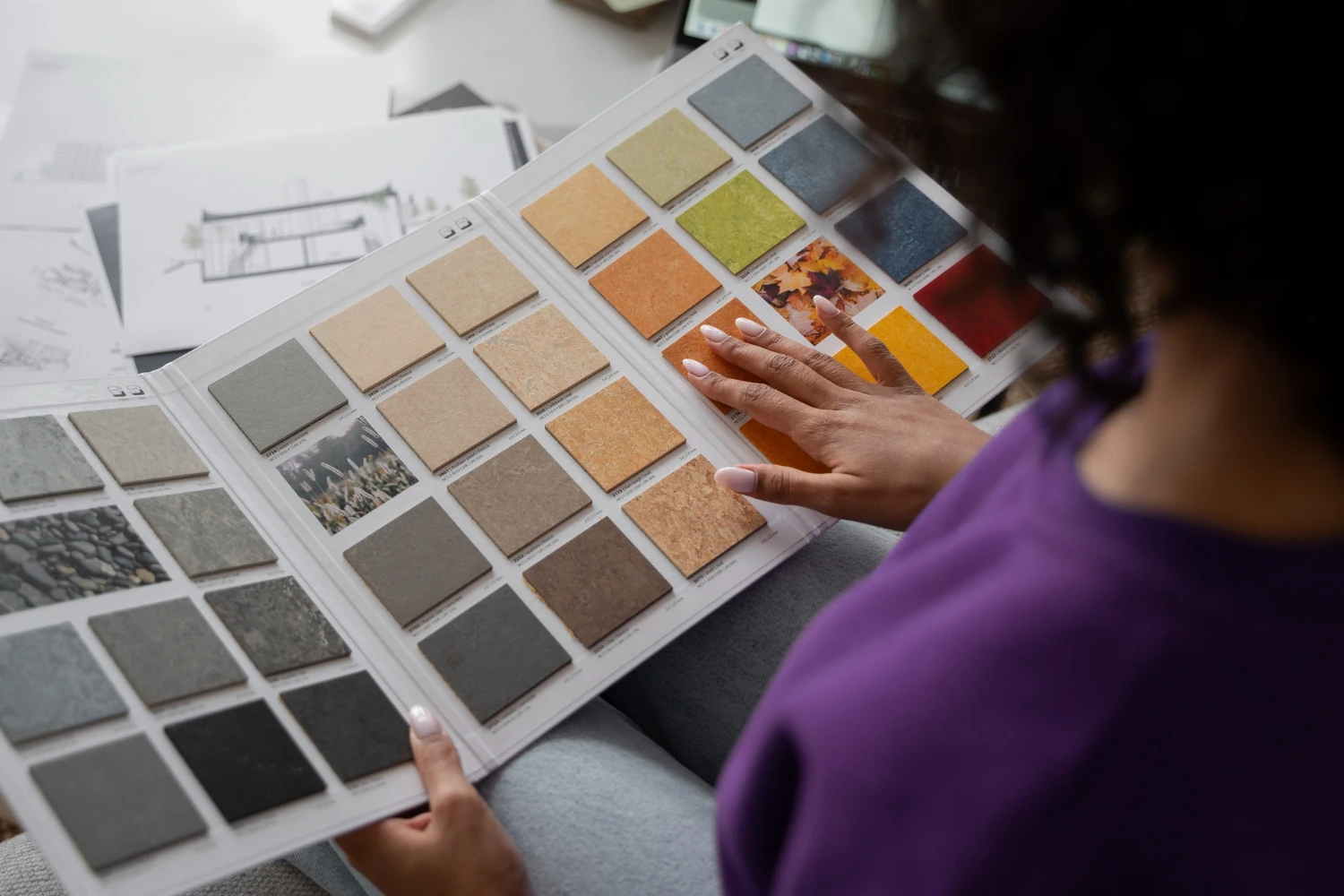 A lady choosing tiles from catelog
